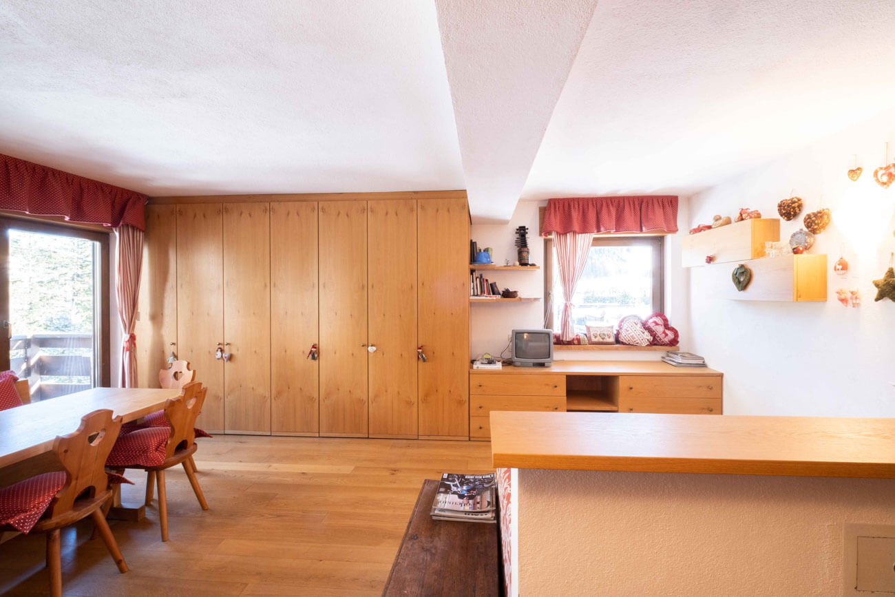 Zona giorno con cucina e armadiatura in legno